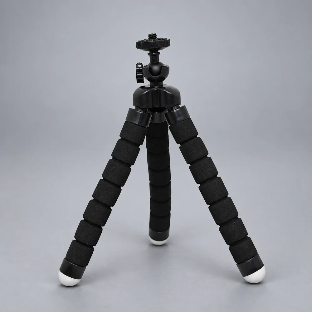 Black three-leg flexible mini tripod in a neutral studio, AI-assisted illustrative image; selected U clip is included but not shown